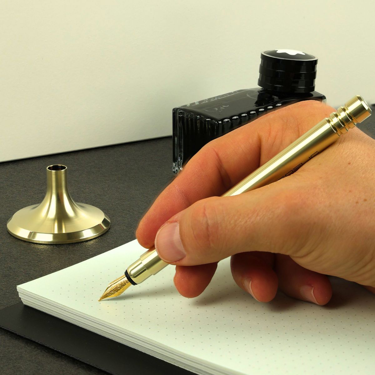 EDELIG DeskPen V4INK Schreibgerät aus Edelstahl mit PVD- Hellgold-Beschichtung auf einem Schreibtisch.