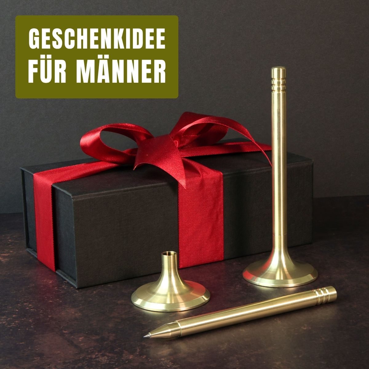 Das Bild präsentiert das Schreibgerät V4INK als eine originelle Geschenkidee für Männer. Vor einem stilvollen schwarzen Geschenkkarton mit einer roten Schleife liegt ein Tintenroller V4INK, der aus massivem Edelstahl in PVD- Hellgold gefertigt ist. Dieser Tintenroller ist die ideale Wahl für exklusive Geschenke zu besonderen Anlässen und Ereignissen.
