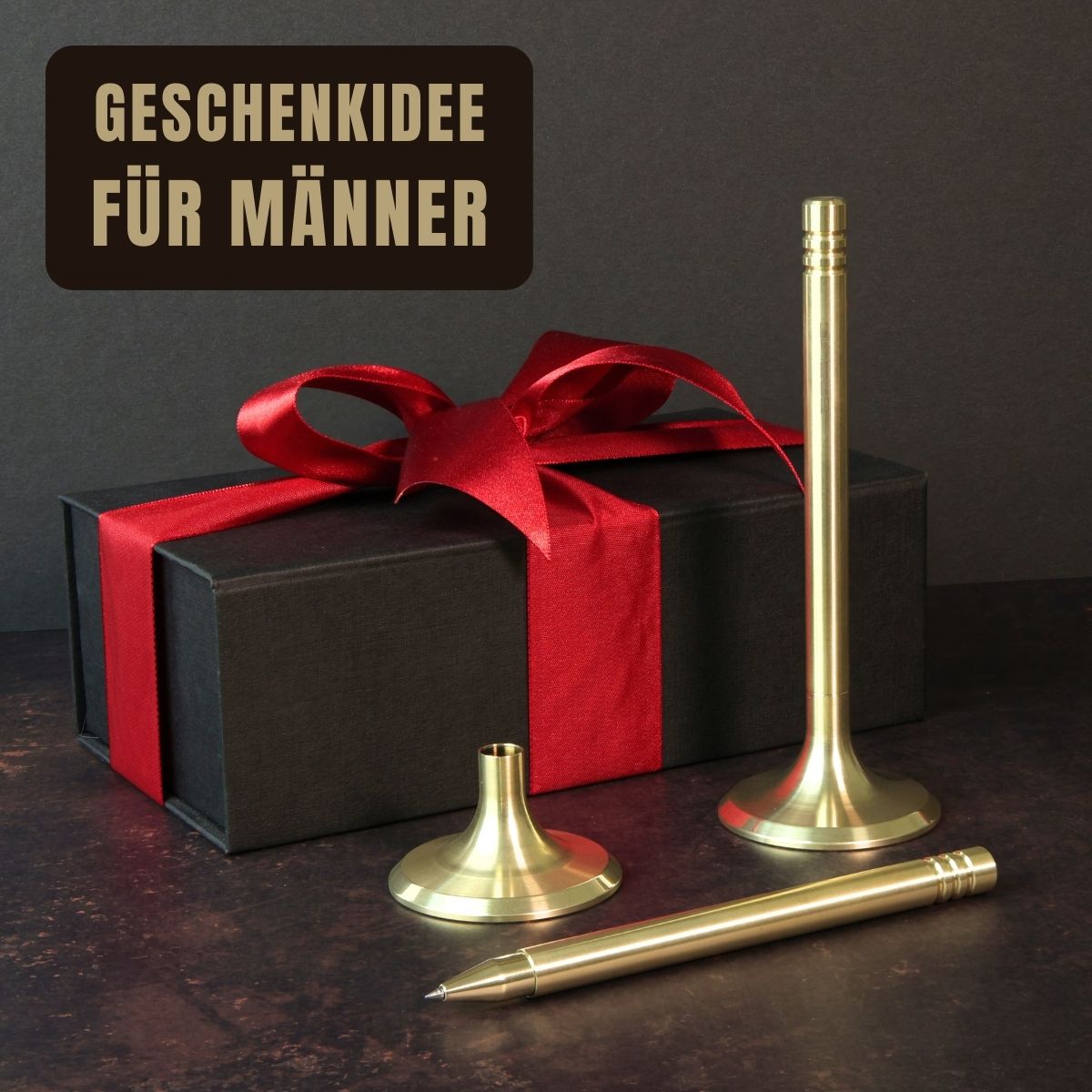 Das Bild präsentiert das Schreibgerät V4INK als eine originelle Geschenkidee für Männer. Vor einem stilvollen schwarzen Geschenkkarton mit einer roten Schleife liegt ein Tintenroller V4INK, der aus massivem Edelstahl in PVD-Hellgold gefertigt ist. Dieser Tintenroller ist die ideale Wahl für exklusive Geschenke zu besonderen Anlässen und Ereignissen.