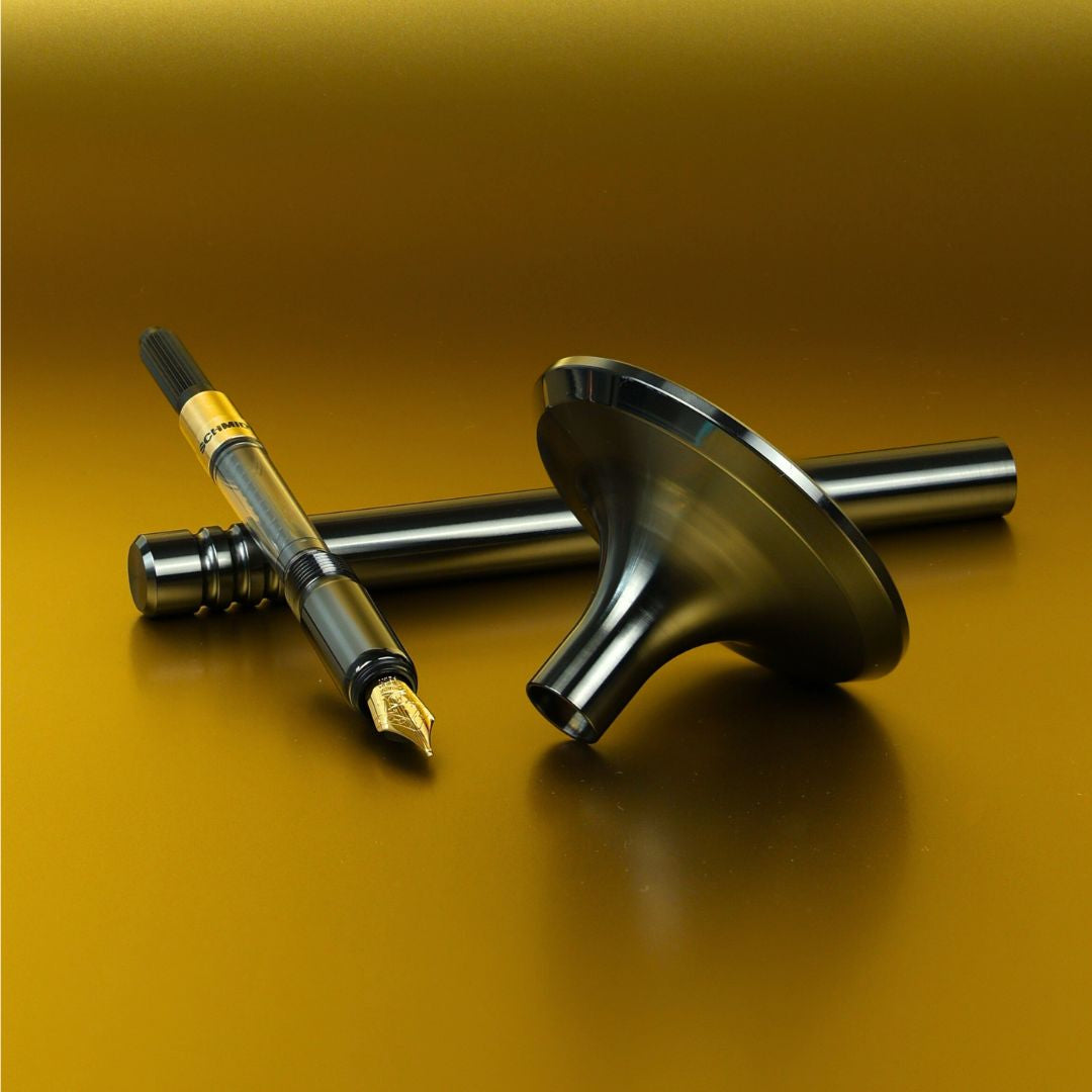 Auf einem goldfarbenen Hintergrund liegen drei luxuriöse Füllfederhalter in edlen Metall- Finishes: DLC- Anthrazit, PVD- Kupfer und PVD- Kupfer. Die Schreibgeräte zeichnen sich durch ihre elegante PVD- Beschichtung aus, die ihnen eine besonders widerstandsfähige und exklusive Oberfläche verleiht. Im Hintergrund ist ein glänzendes Standfuß aus purem Edelstahl als Basis zu sehen.