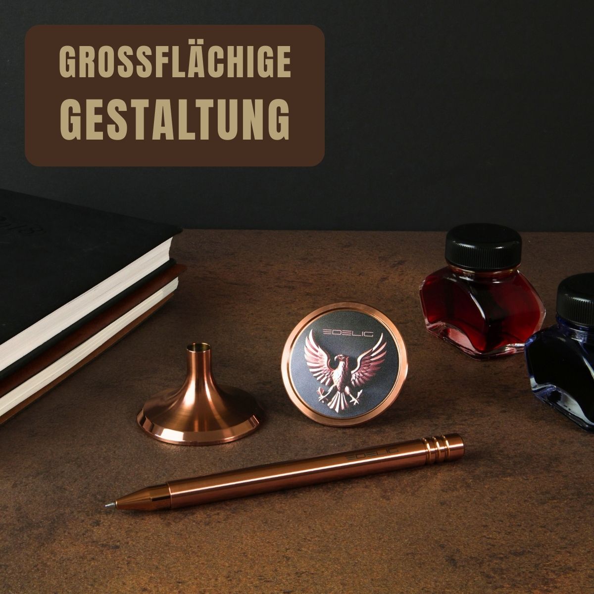 Das Bild zeigt einen exklusiven Tintenroller in PVD- Kupfer mit passender Stifthalterung und großflächig personalisiertem Ventilteller. Auf der runden Fläche ist ein detailreich graviertes Adler- Motiv mit dem Schriftzug „EDELIG“ zu sehen – ein Beispiel für die vielfältigen Möglichkeiten der V4INK- Personalisierung nach Wunsch. Daneben liegen edle Tintenfässer in Rot und Blau sowie ein Notizbuch, die die Verbindung von traditioneller Schreibkultur und moderner Ingenieurskunst unterstreichen.